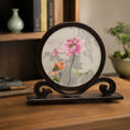 Load image into Gallery viewer, Lotus embroidery ornament displayed on a wooden desk with books, an inkstone, and a bonsai in a softly lit scholar's room