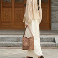 Load image into Gallery viewer, SinoCrafted brown scrolling vine embroidery tote bag styled over the shoulder, showcasing intricate Chinese-inspired embroidered details.