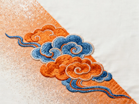 Hand-embroidered Chinese auspicious cloud motifs in orange and blue silk thread on shimmering fabric, Su embroidery technique