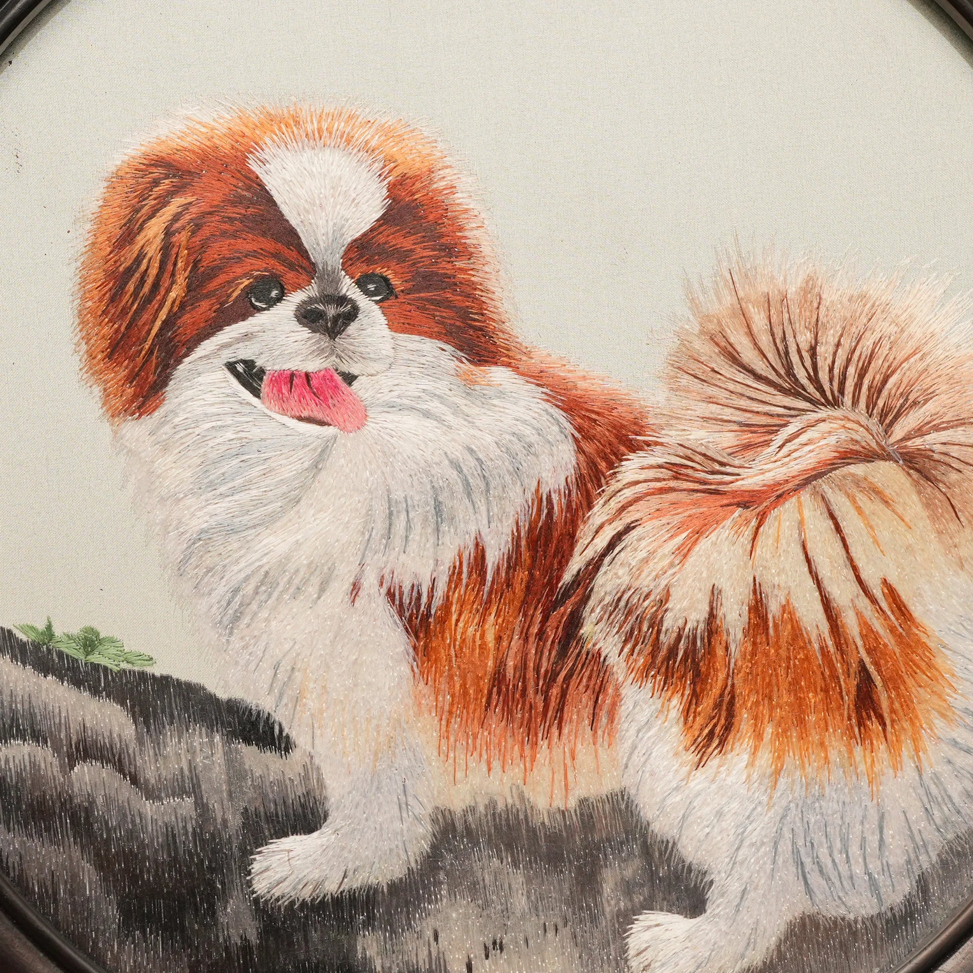 Double-sided embroidery of a brown and white Pekingese dog standing on a rock in a circular frame within a rectangular hardwood screen stand