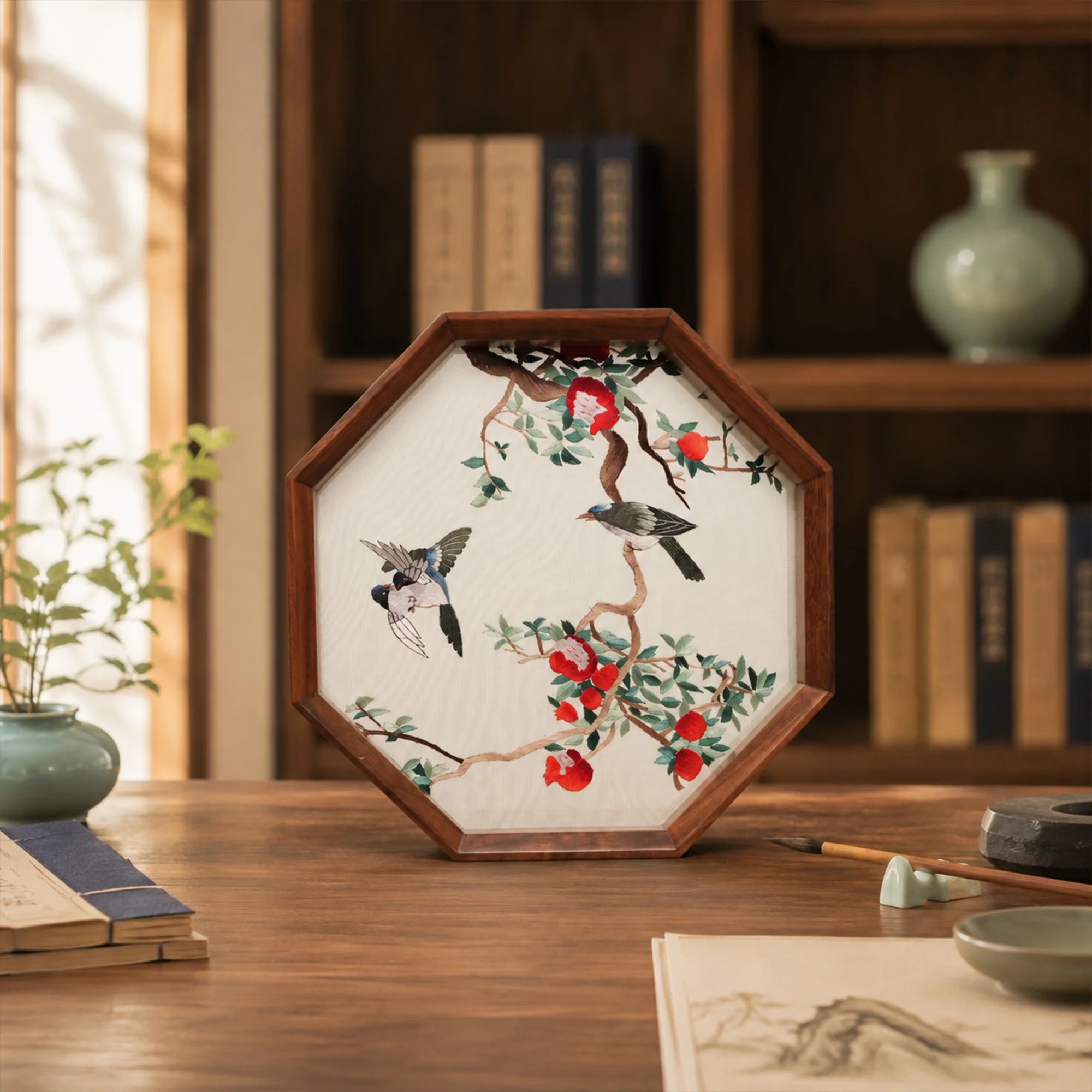 Double-sided embroidery of two birds among red pomegranate flowers and fruit in an octagonal hardwood frame on cream silk