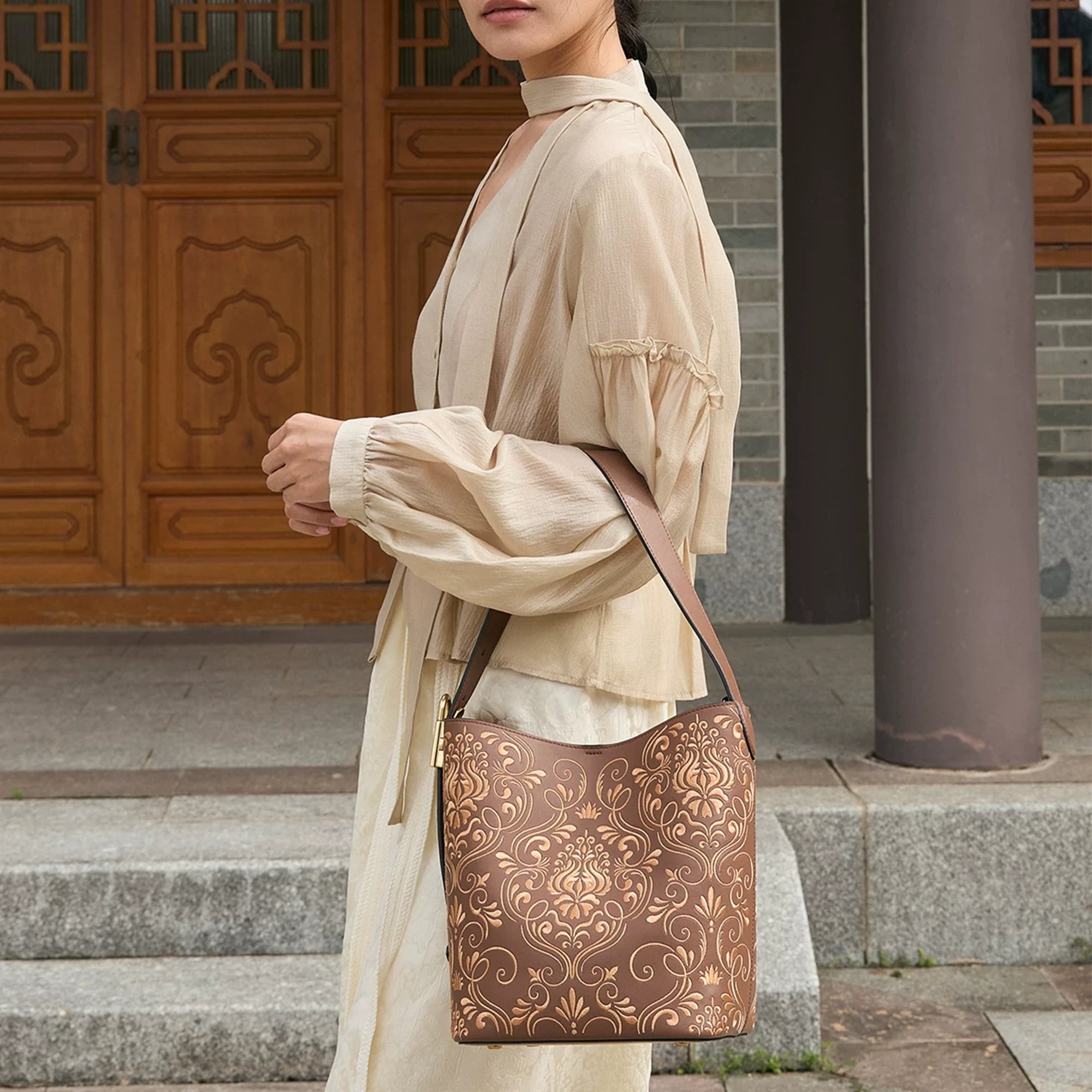 SinoCrafted brown scrolling vine embroidery tote bag styled over the shoulder, showcasing intricate Chinese-inspired embroidered details.