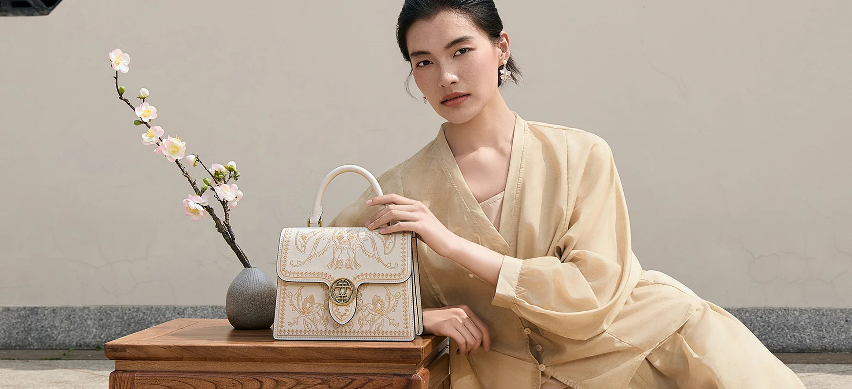 Elegant white leather top handle satchel bag featuring floral Suzhou embroidery with traditional Chinese hollow gold lock