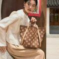Load image into Gallery viewer, Chinese embroidery luxury tote bag featuring Tang Dynasty inspired Baoxiang flower pattern, a modern oriental leather handbag carried by a woman in traditional Chinese style setting
