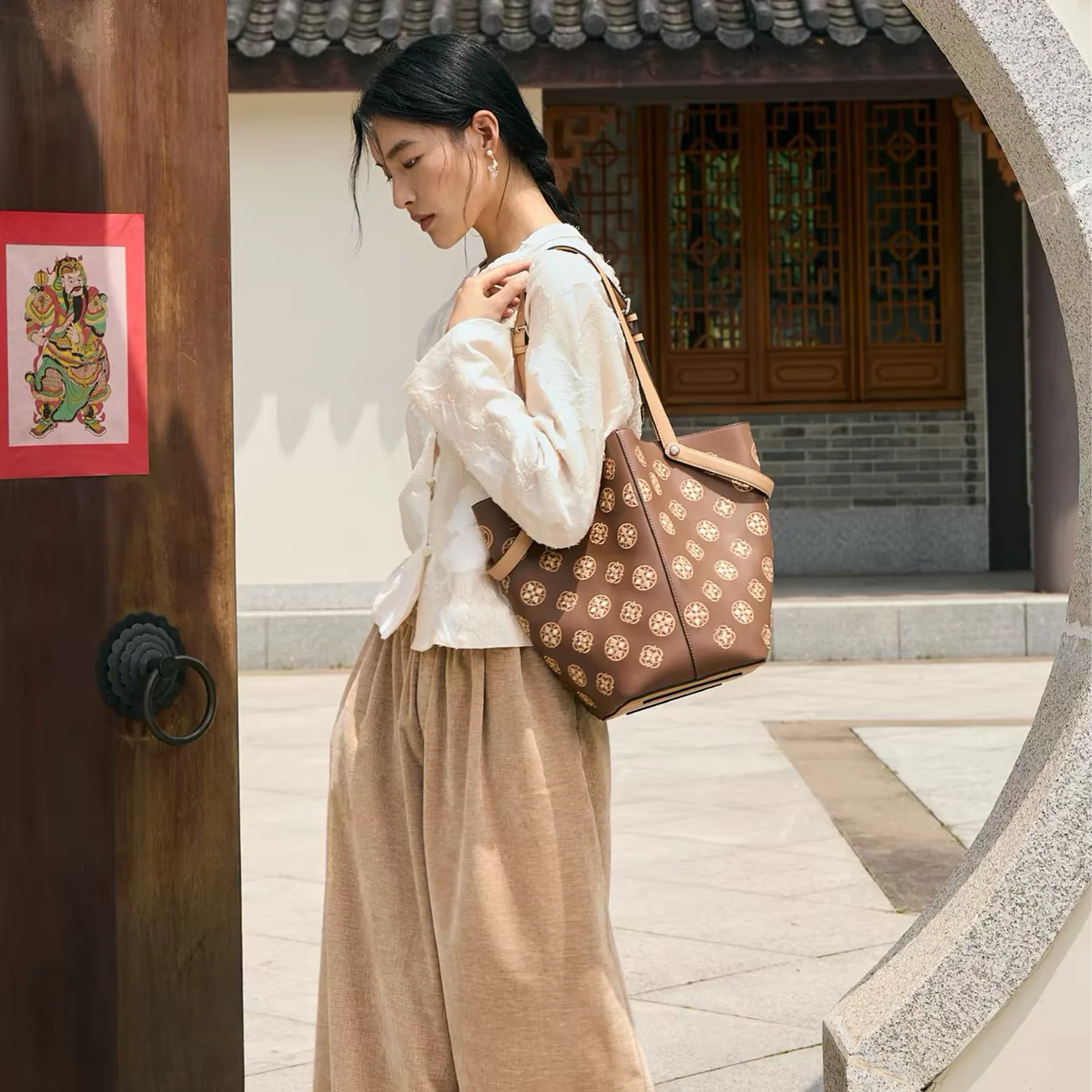 Woman carrying a luxury Chinese embroidery tote bag with Tang Dynasty inspired Baoxiang flower pattern, an elegant oriental leather handbag blending traditional Chinese craftsmanship with modern fashion