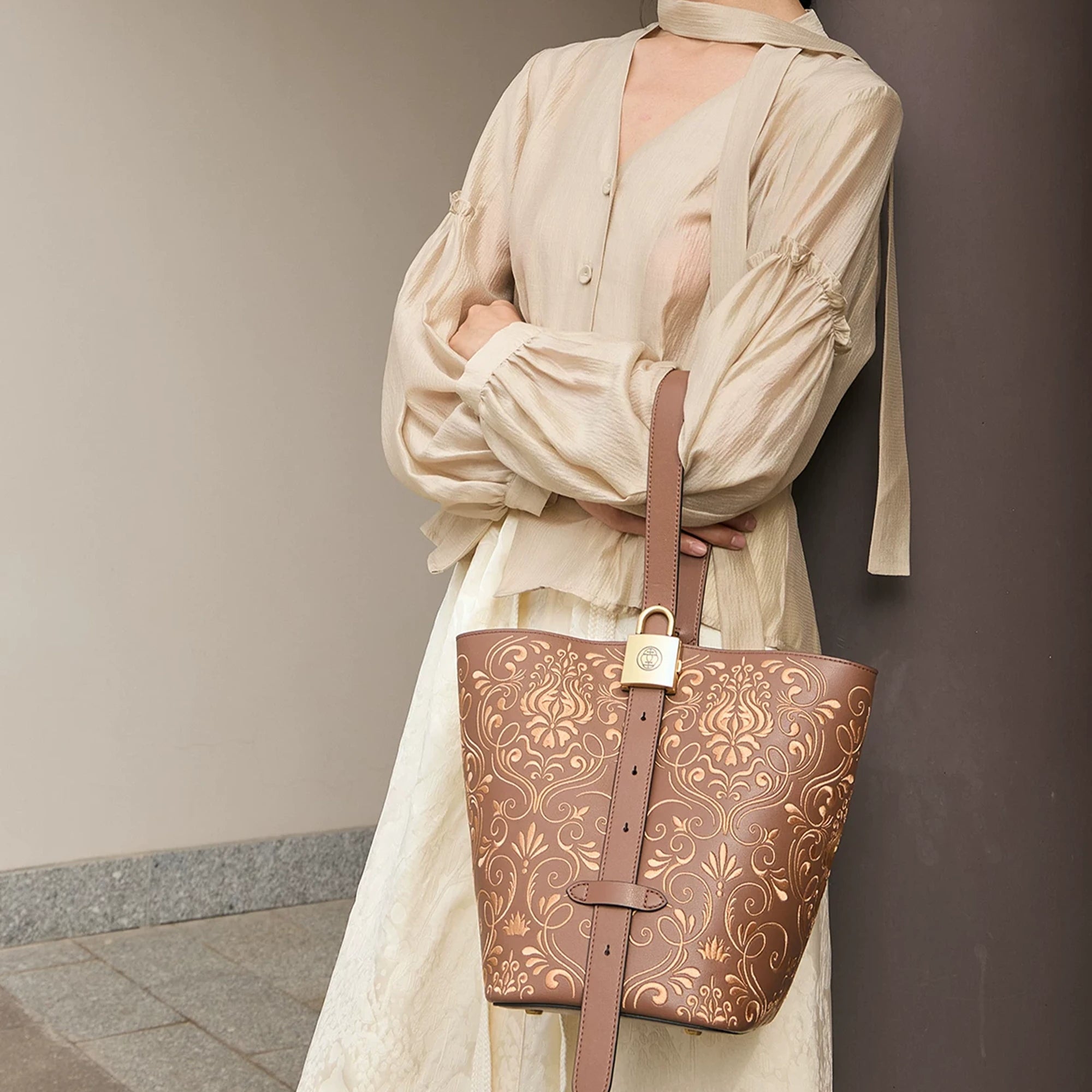 SinoCrafted brown scrolling vine embroidery tote bag styled over the shoulder, showcasing intricate Chinese-inspired embroidered details.